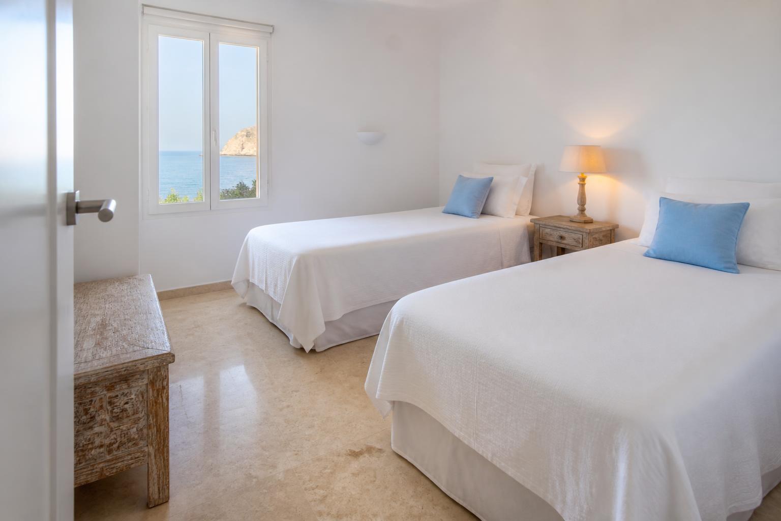 Sovrum två med två enkelsängar och havsglimt