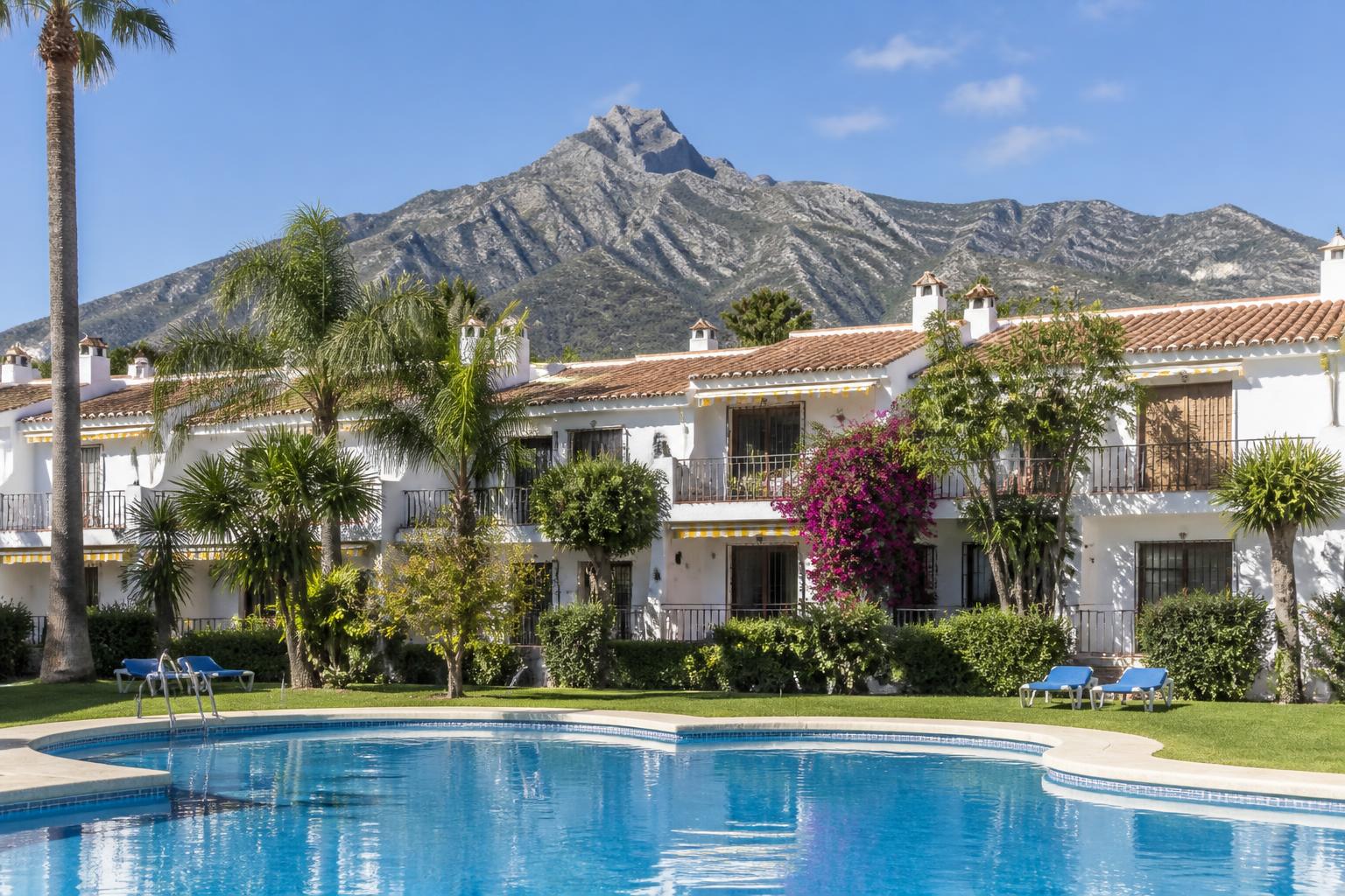 Områdets pool och vita hus med bougainvillea